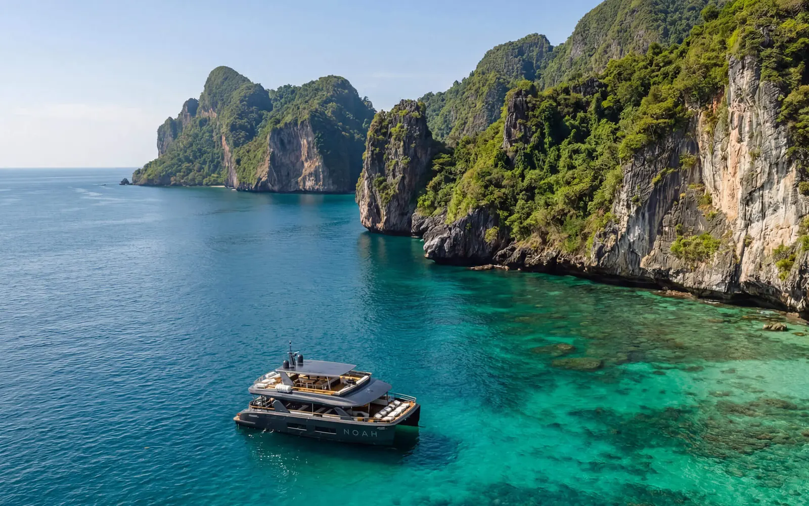 Aerial view of a catamaran cruising a turquoise Andaman bay